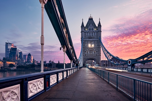 Skyline of London. Tower Bridge against cityscape with skyscrapes at colorful sunrise.
