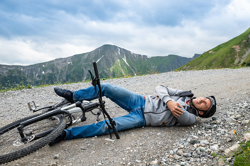 Man Lying On Ground After Accident On Mountain Bike
