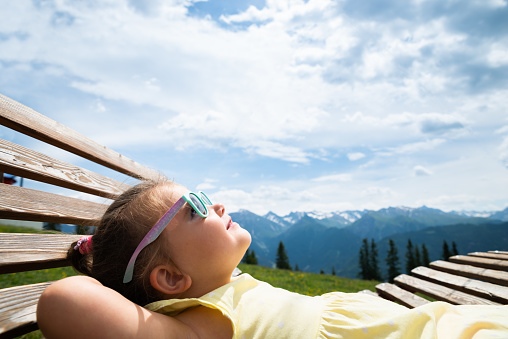 Little Girl Relaxing In Sun Lounger In Mountains