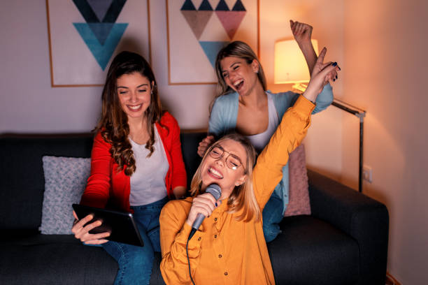 istock Three female friends having fun playing karaoke at home. 1171903868