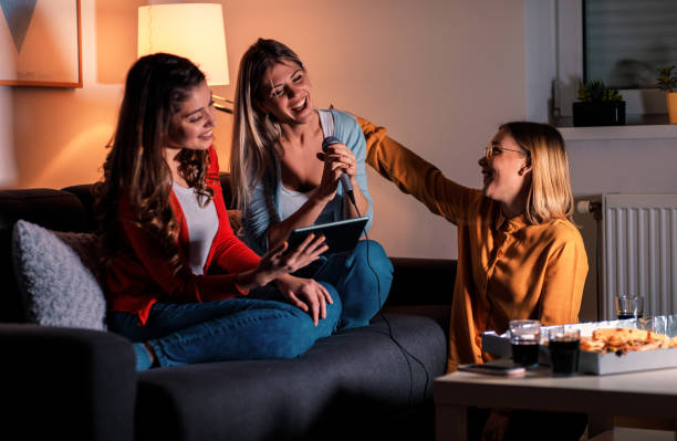 istock Three female friends having fun playing karaoke at home. 1171904075