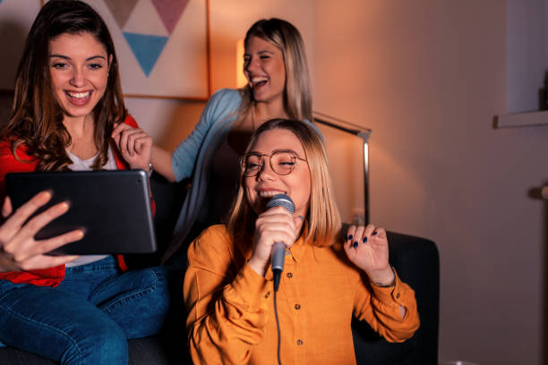 istock Three female friends having fun playing karaoke at home. 1171904209