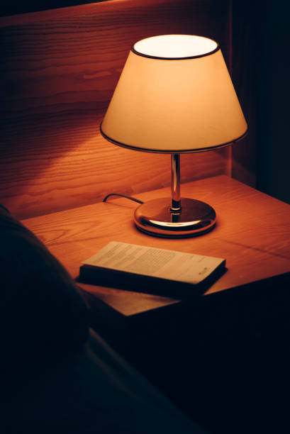 istock Book and vintage lamp on night table in hotel room 1171904905