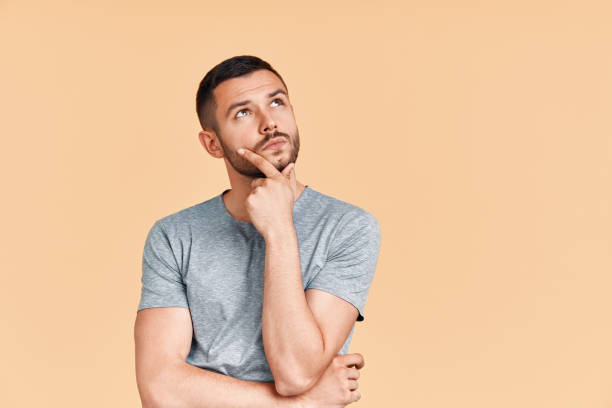 istock Young thoughtful man thinking and looking aside on copy space isolated on yellow background 1171905066