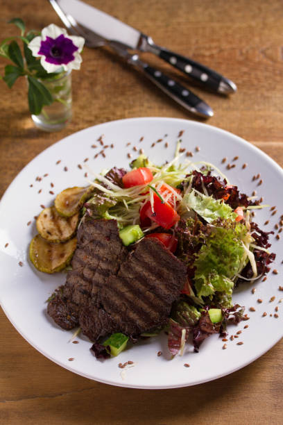 istock Beef salad: grilled beef steaks with tomatoes, cucumbers, zucchini, lettuce and cabbage, sprinkled with flax seeds. 1171908927