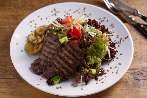istock Beef salad: grilled beef steaks with tomatoes, cucumbers, zucchini, lettuce and cabbage, sprinkled with flax seeds. 1171909020