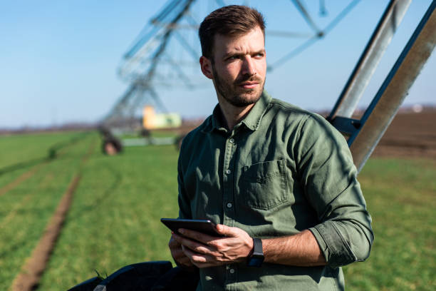 istock Young farmer standing in wheat field and setup irrigation system on tablet. 1171909447