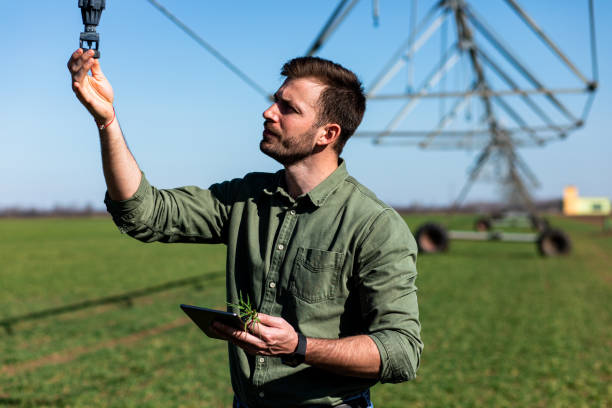 istock Young farmer standing in wheat field and setup irrigation system on tablet. 1171909450
