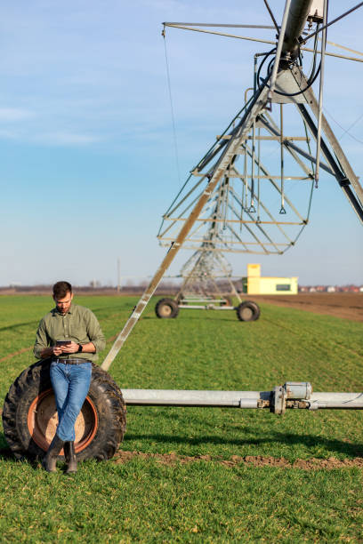 istock Young farmer standing in wheat field and setup irrigation system on tablet. 1171909452
