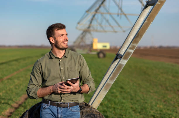 istock Young farmer standing in wheat field and setup irrigation system on tablet. 1171910420