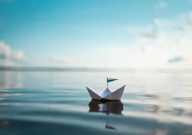 Small Paper Boat Floats on Calm Water
