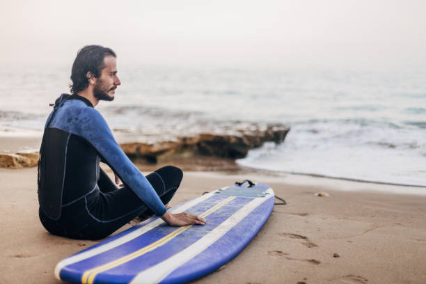 istock Surfer sitting on the beach and relaxing 1171913492