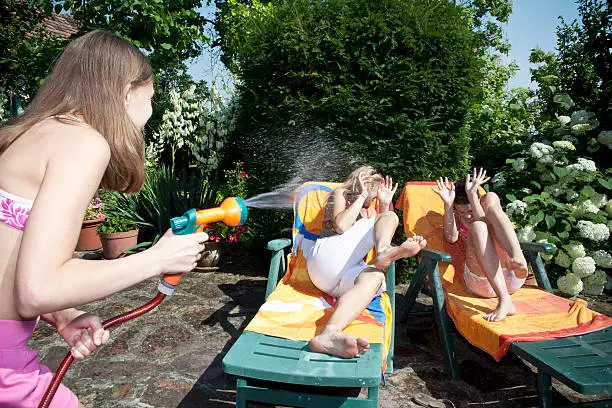 Photo of Girl sprays water on mum and sister