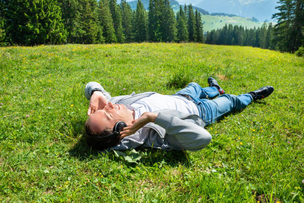 istock Man Lying In Grass Listening Music 1171914767