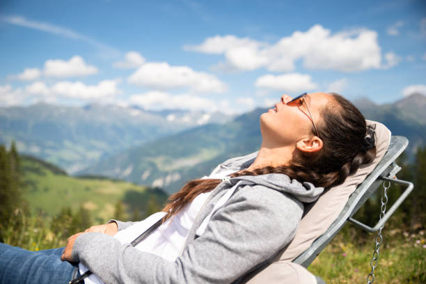 Woman Relaxing In Sun Lounger In Mountains