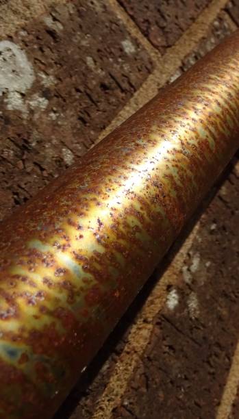 istock Rusted round metal railing on a brick wall. 1171915404