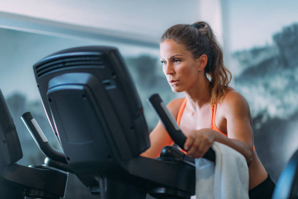 istock Woman Exercising on Cycling Machine 1171916554
