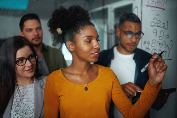 multi-ethnic group of business people planning startup project on glass board in office - pen business person men standing imagens e fotografias de stock