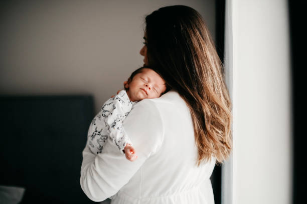 istock Smiling mother with sleeping newborn son on 1171917782