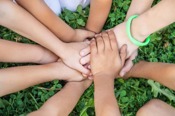 istock children's hands together on a background of grass. Selective focus. 1171917997