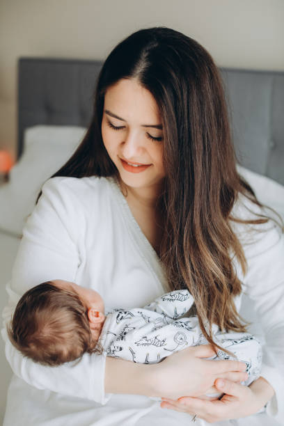 istock Smiling mother with sleeping newborn son on 1171918247