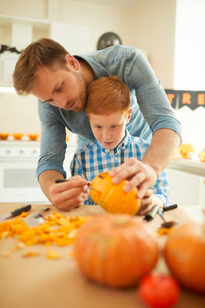 istock Father and son preparing pumpkin 1171919584