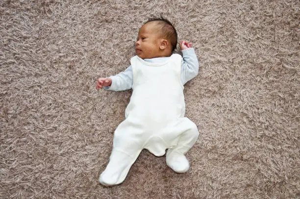 A child with Down Syndrome on a rug