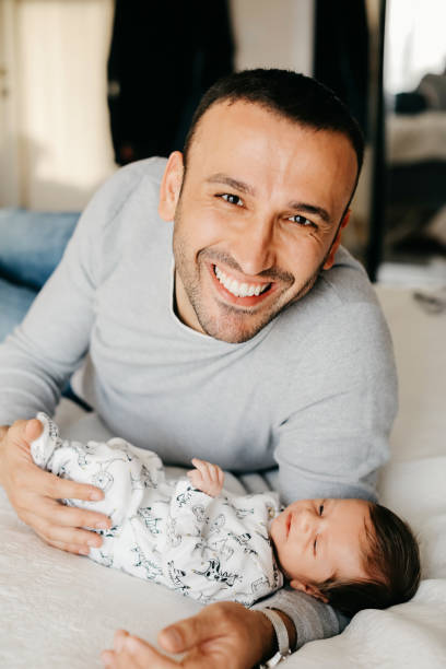 istock Smiling father with sleeping newborn son on 1171923209