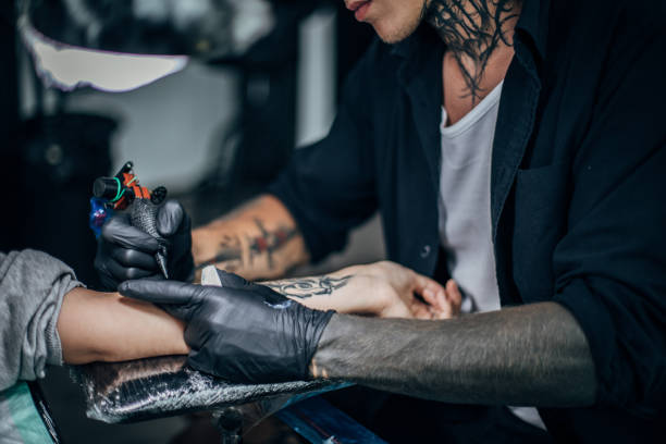 istock Artist tattooing lady's arm 1171924322