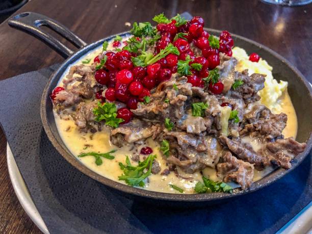 Reindeer stew with loganberries on potato mash: Reindeer stew with raw currant loganberries on almond potato mash served in a pot with handle norrbotten province stock pictures, royalty-free photos & images