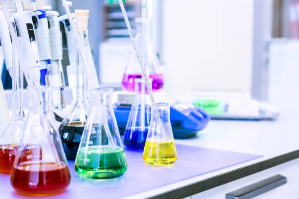 istock Chemical analysis, pharmacology and laboratory concept. Flasks with colored liquid reagents in a science laboratory. Blue toned 1171926115