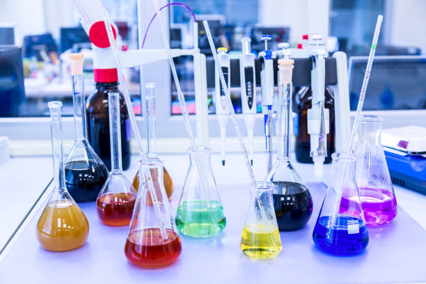 istock Chemical analysis, pharmacology and laboratory concept. Flasks with colored liquid reagents in a science laboratory. Blue toned 1171926120
