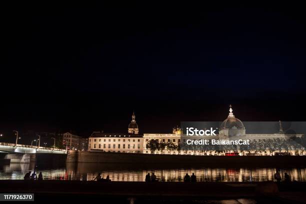 French People Sitting At Night On The Riverbank Of The Quais De Rhone Facing Hotel Dieu One Of The Main Monuments Of The City For The Tradition Of Apero Stock Photo - Download Image Now