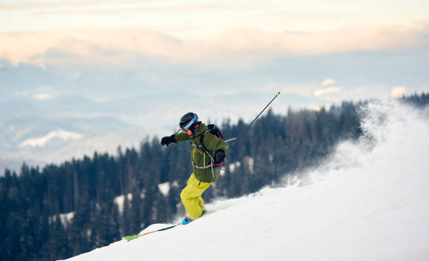 skifahrer steigen vom schneebedeckten hochgebirgsgipfel ab. extremes back-country-ski-konzept. blick auf die berge im hintergrund - back country skiing extreme skiing skiing ski stock-fotos und bilder