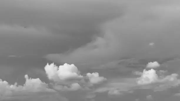 Dramatic dark heavy rain clouds makes the sky black on a monsoon evening time of a day in Mid June. Its pattern like tornado, Hurricane or thunderstorm. Cloudy stormy black and white Meteorology background concept. Clouds flying passing rolling or moving over the sky.