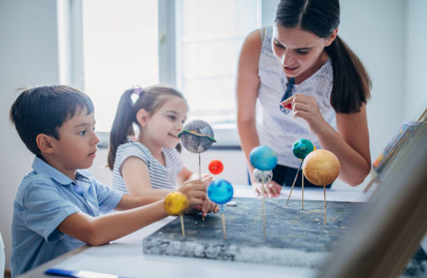 istock Teacher and two kids in private elementary school 1171927539