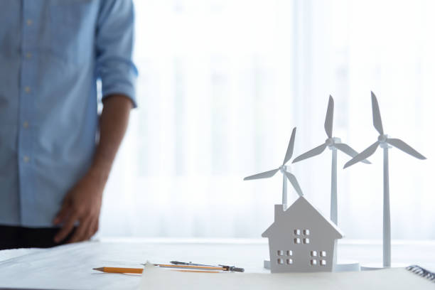istock Three white wind turbine generating electricity on table in office modern 1171927856