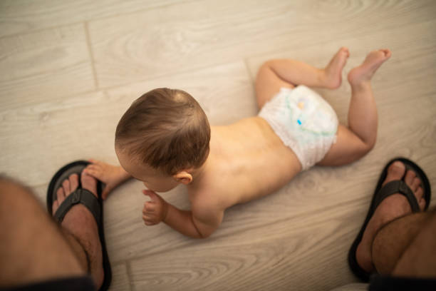 istock Curios baby boy playing with father's slippers 1171927873