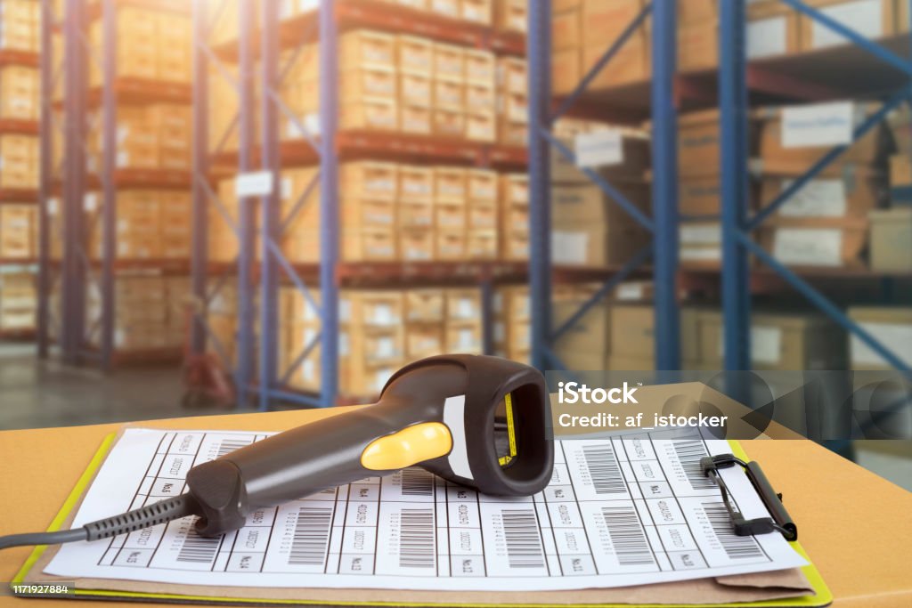 Barcode scanner in front of modern warehouse and scanning code Barcode scanner in front of modern warehouse and scanning code on cardboard box Bar Code Stock Photo