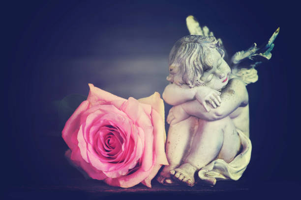 istock Guardian angel and rose on dark background 1171929328