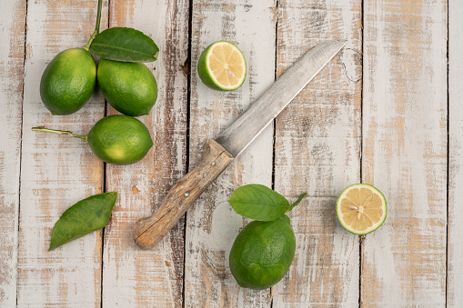 sliced limes and knife on a wooden table
