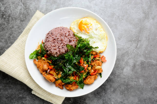 istock Crispy chicken cooked with green basil, served with steamed rice and fried egg, hot and spicy dish with basil leaves.