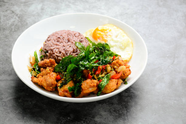 istock Crispy chicken cooked with green basil, served with steamed rice and fried egg, hot and spicy dish with basil leaves.