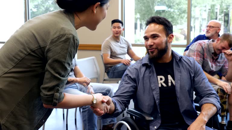 Mid adult wheelchair-bound veteran attends meeting for veterans