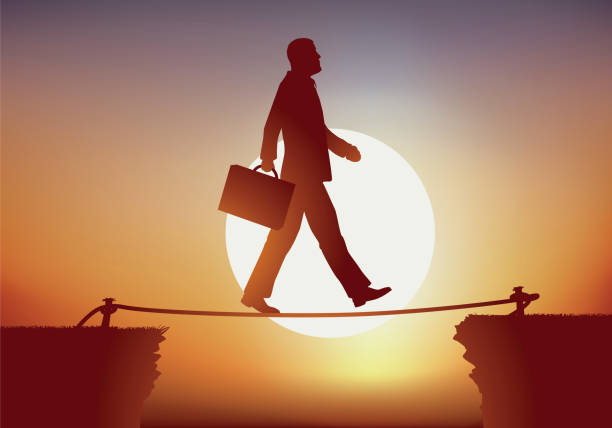 istock A businessman crosses a crevasse in balance on a wire. 1171938670