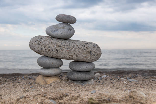 istock stone tower stacked on a beach as a cairn or markerwith a dramatic sky 1171950103