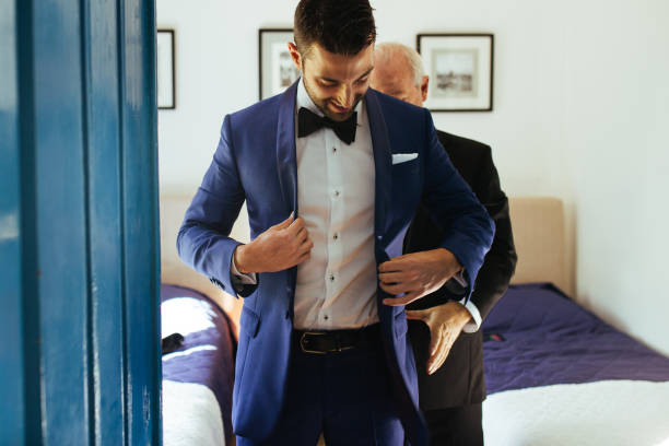 彼のスーツで新郎の息子を助ける父 - dressed in suit ストックフォトと画像