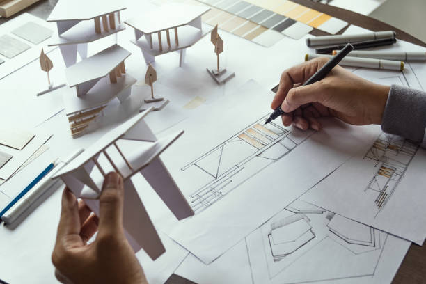 istock architect design working drawing sketch plans blueprints and making architectural construction model in architect studio 1171952539