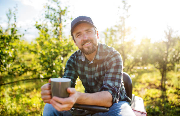 un agricultor maduro con taza de café al aire libre en huerto, descansando. - resting place fotografías e imágenes de stock