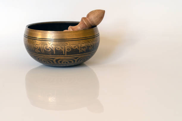 istock Singing bowl close-up, soothing and meditative. Singing bowl with sanskrit engraving pattern and wooden mallet Isolated on white background. 1171955848